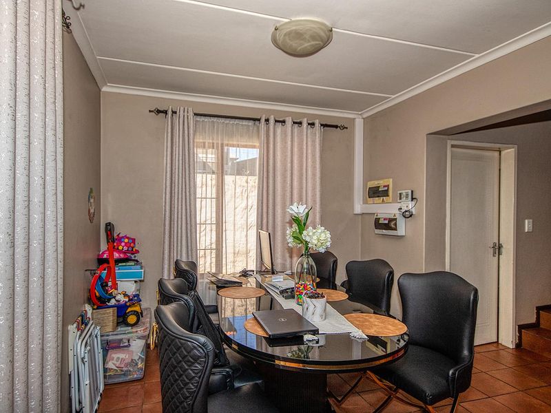 Dining room featuring tiled flooring and neutral wall tones, providing a functional space for family meals and gatherings.