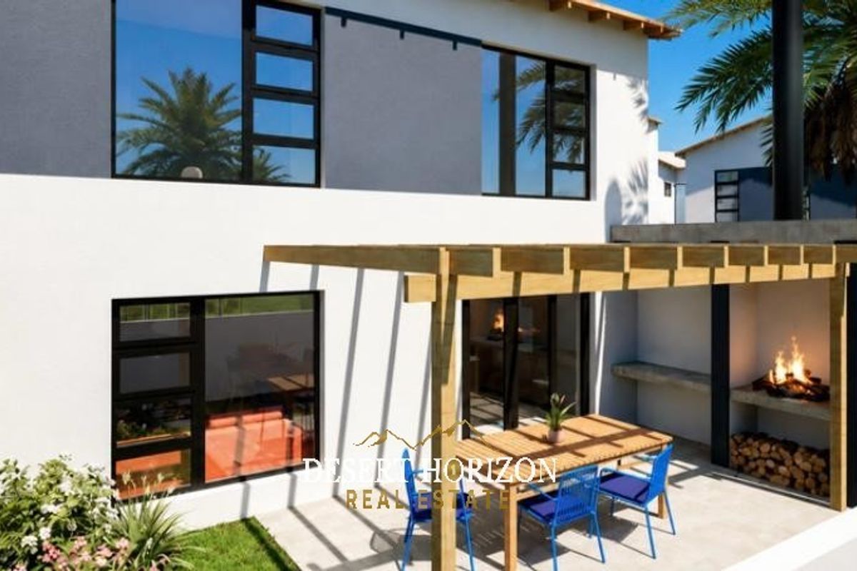 Rear exterior view of the townhouse featuring a paved patio with a timber pergola and a built-in braai area.