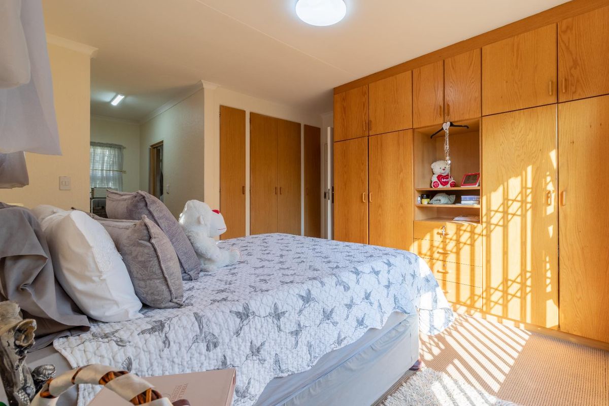 A bedroom featuring extensive built-in wooden cabinetry and wardrobes, providing ample storage space with a functional layout.
