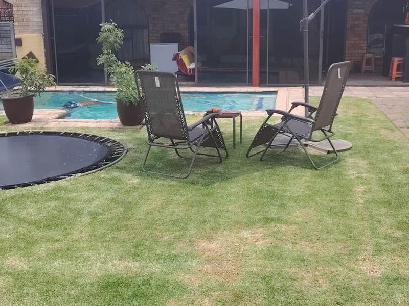 A backyard pool area featuring a swimming pool, paved patio space, and direct access to the home through sliding glass doors.