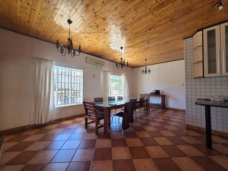 Open plan living and dining area featuring a timber ceiling, tiled flooring, and split system air conditioning.