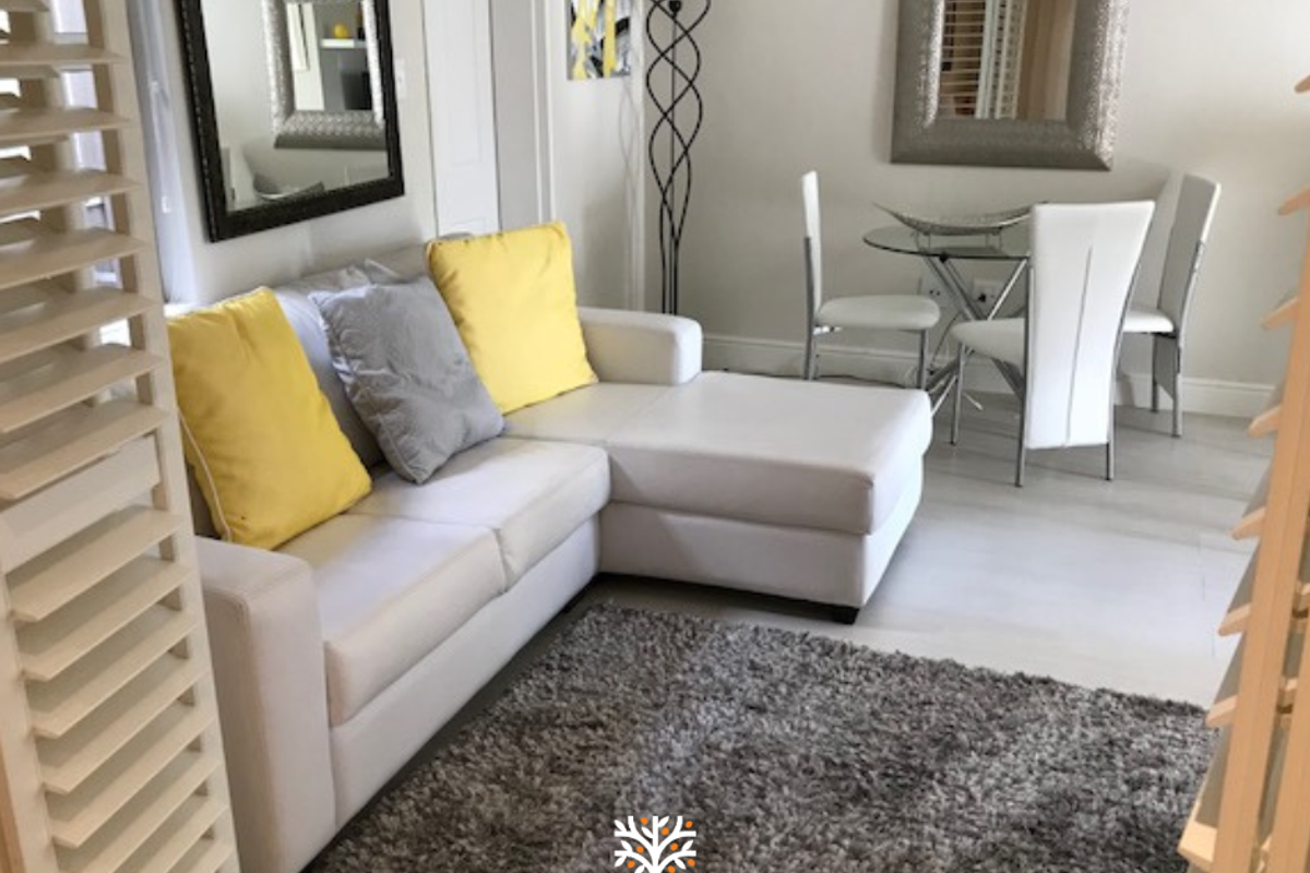 A bright and well-maintained living area featuring tiled flooring and plantation-style shutters, creating a clean and inviting space.