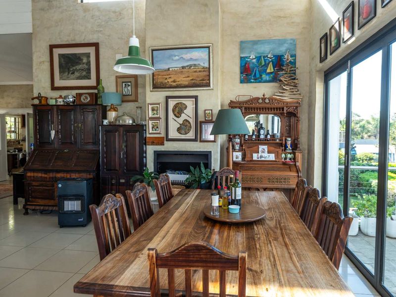 Spacious dining area featuring a built-in fireplace, high ceilings, and large sliding glass doors that provide ample natural light and access to the outdoors.