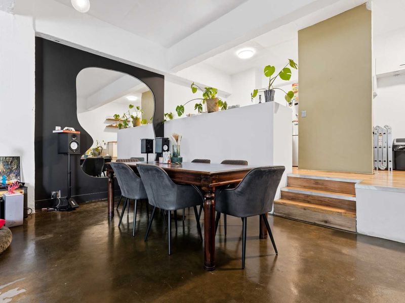 An open-plan office space featuring polished concrete floors, a raised platform area, and a modern partition wall with integrated lighting.