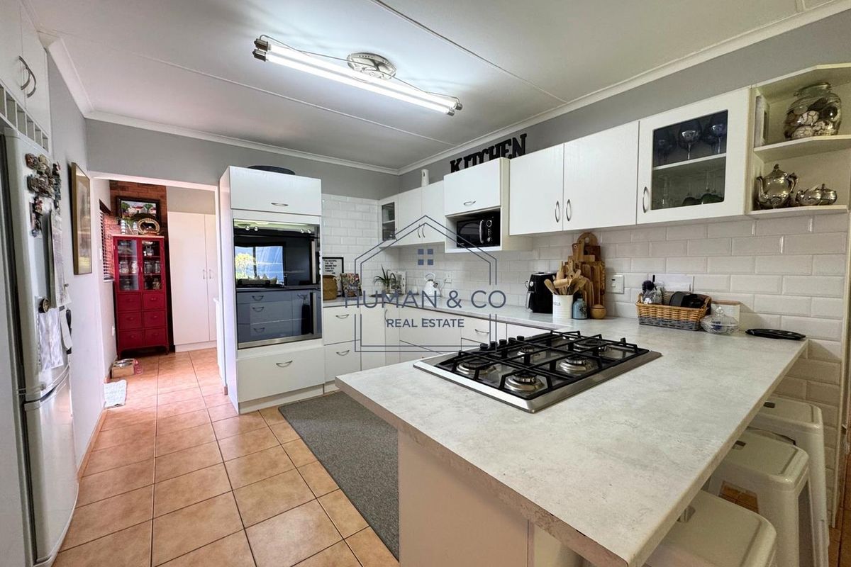 A functional kitchen featuring white cabinetry, a built-in oven, a gas hob on the island, and subway tile backsplash.