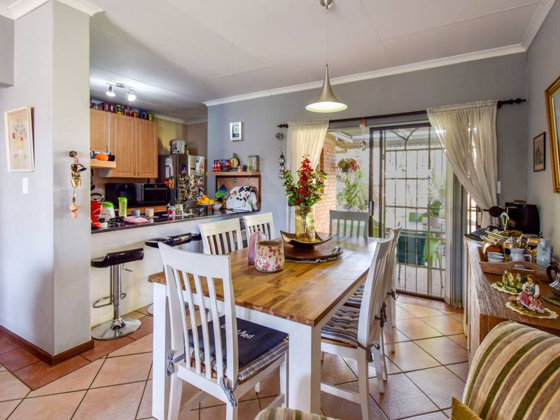 Open plan dining and kitchen area featuring tiled flooring, granite countertops, and direct access to the outdoor patio through sliding glass doors.