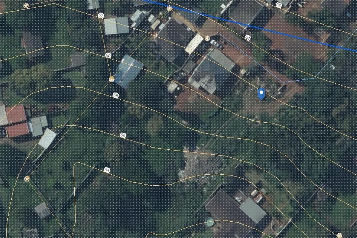 An aerial view of a residential plot featuring overlaid topographic contour lines indicating the elevation profile of the land.