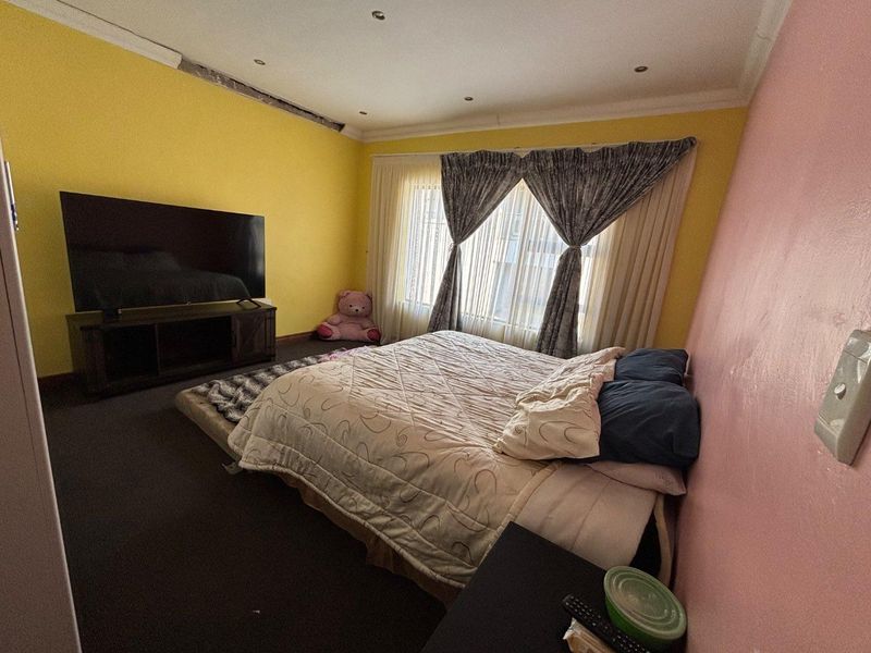 A bedroom featuring recessed downlighting and coving, currently requiring cosmetic attention to the wall and ceiling finishes.