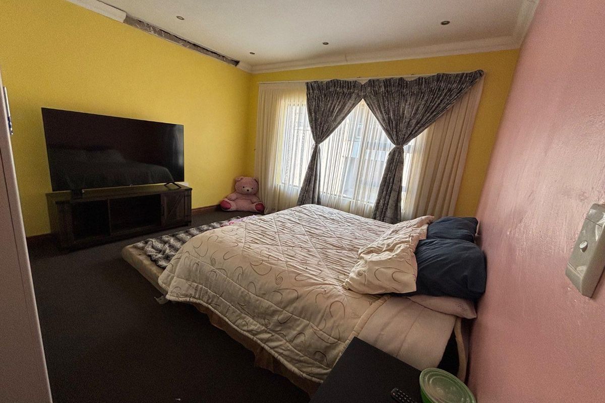 A bedroom featuring recessed downlighting and coving, currently requiring cosmetic attention to the wall and ceiling finishes.