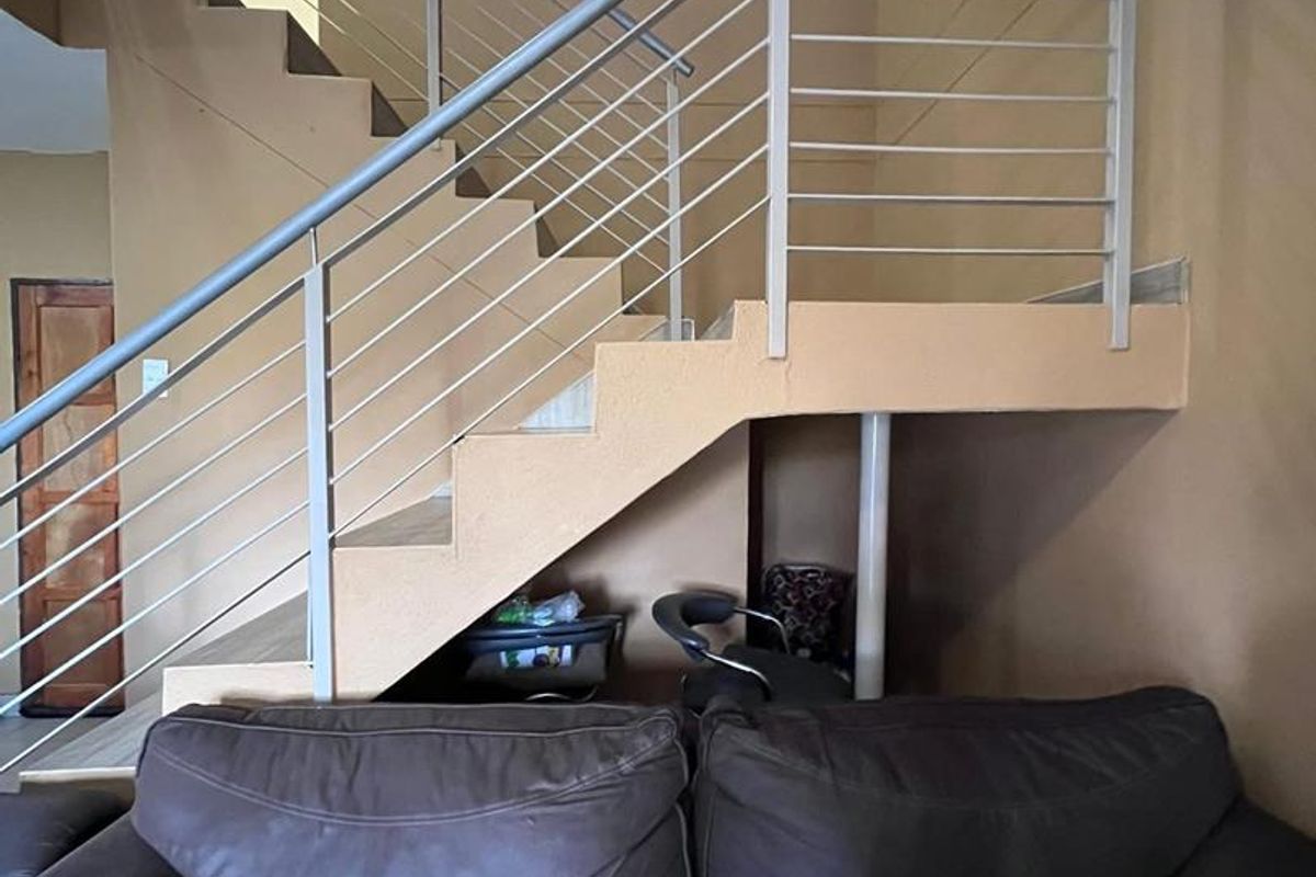 Interior view of a living area featuring a staircase with a modern metal balustrade and handrail.