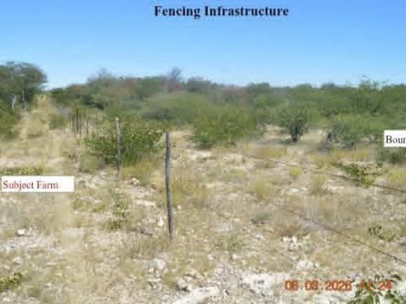View of the farm boundary featuring basic wire fencing and wooden posts across the natural landscape.