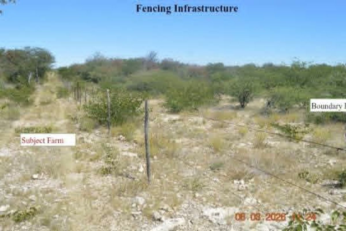 View of the farm boundary featuring basic wire fencing and wooden posts across the natural landscape.