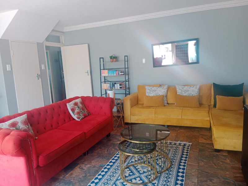 A living room featuring tiled flooring and crown molding, providing a functional space for relaxation.