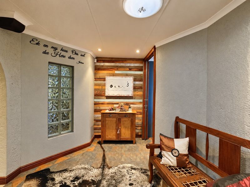 Welcoming entrance hall featuring a unique glass block window, rustic timber accent wall, and durable tiled flooring with recessed lighting.