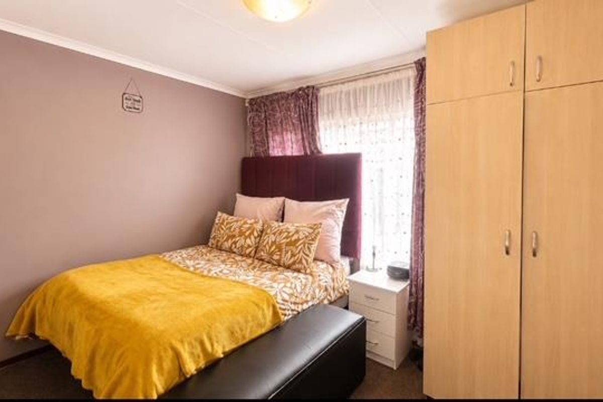 A cozy bedroom featuring a built-in wardrobe and neutral wall finishes, providing a functional and comfortable sleeping space.