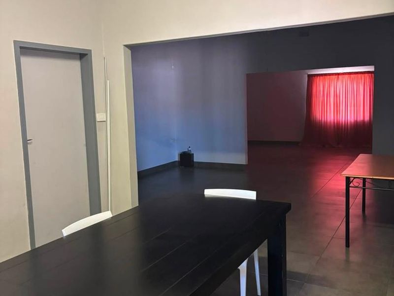 An open-plan living area featuring tiled flooring and neutral wall finishes, providing a versatile space with good flow between connected rooms.