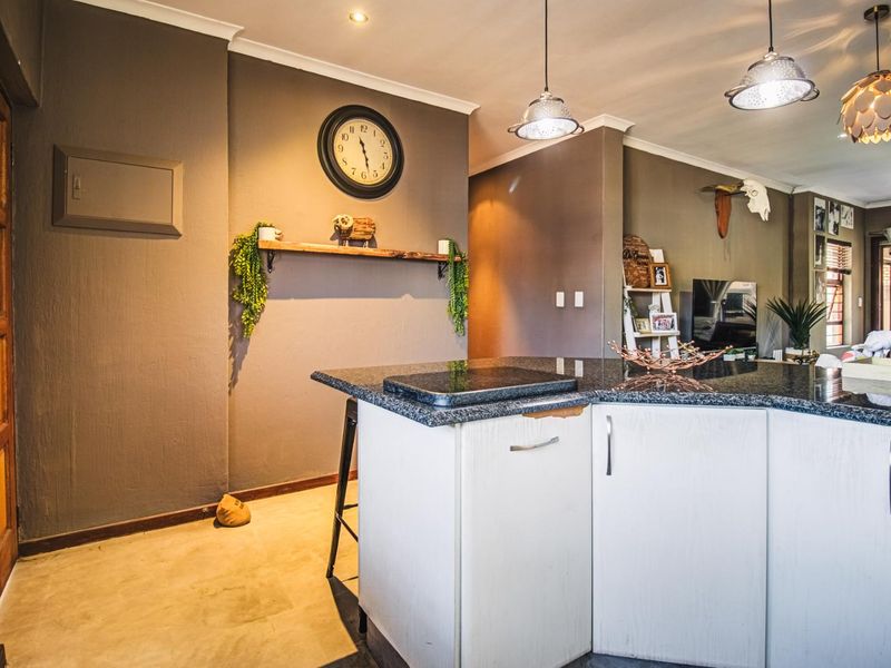 Open plan living area featuring a kitchen island with granite countertops and modern pendant lighting, flowing into the adjacent living space.