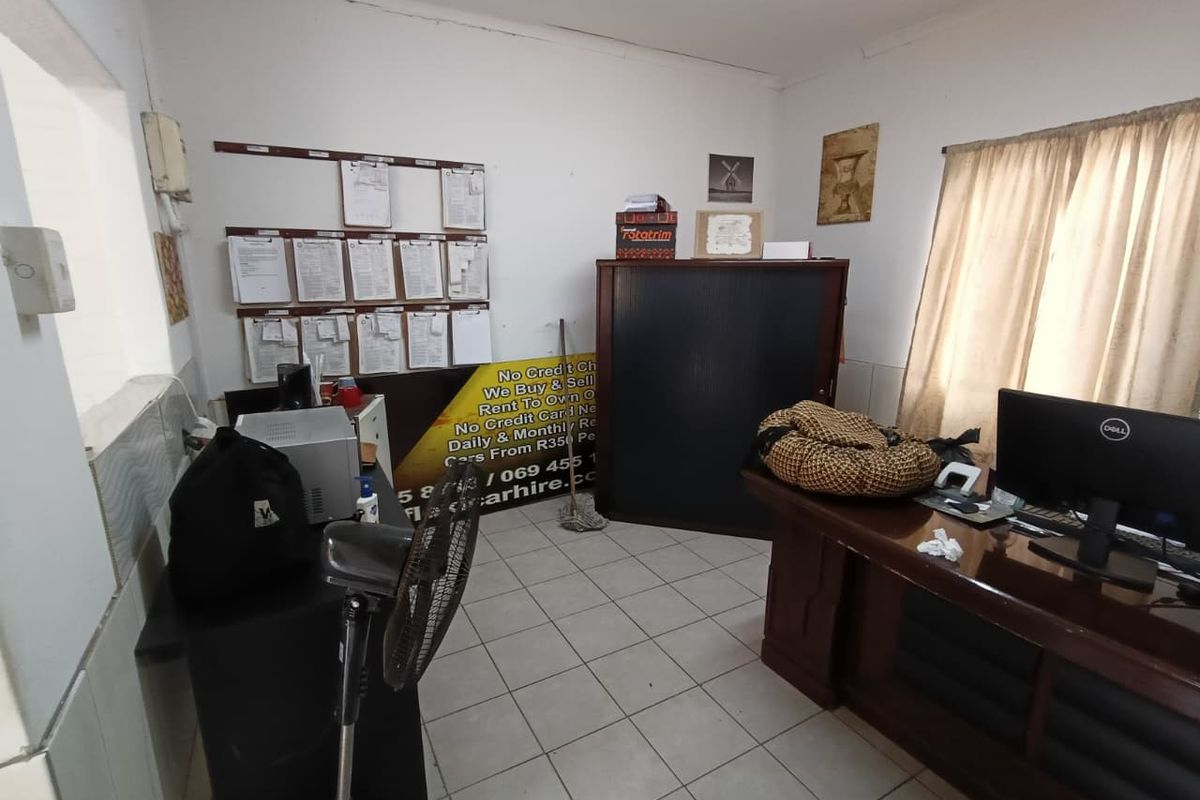 A functional office space featuring tiled flooring and neutral wall finishes, suitable for a professional work environment.
