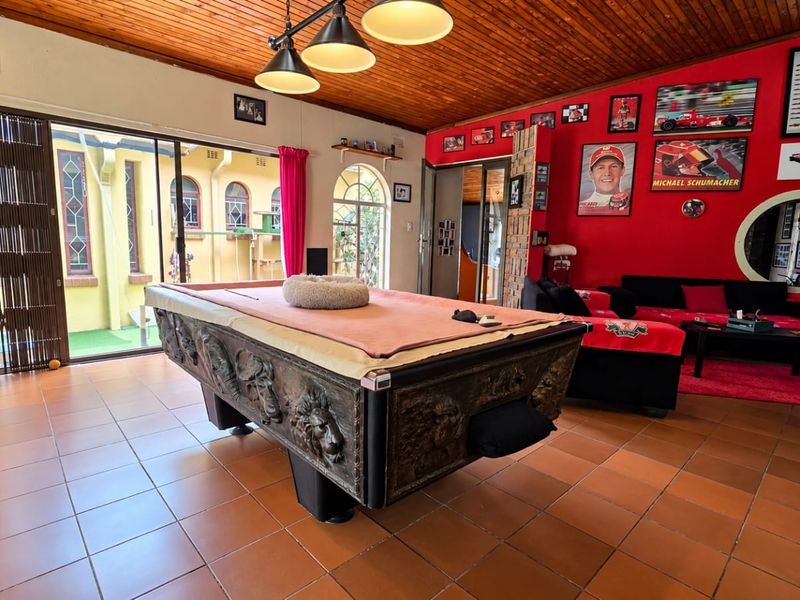 Spacious living area featuring a timber-clad ceiling, ceramic floor tiles, and large sliding glass doors providing access to the outdoor space.