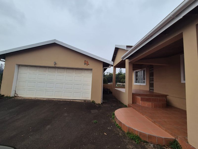 Front exterior view of the townhouse featuring a single garage, paved driveway, and a covered tiled porch entrance.