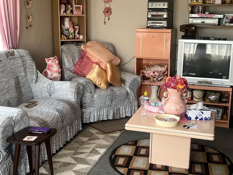 A living room space featuring standard residential finishes, currently occupied by personal belongings and furniture.