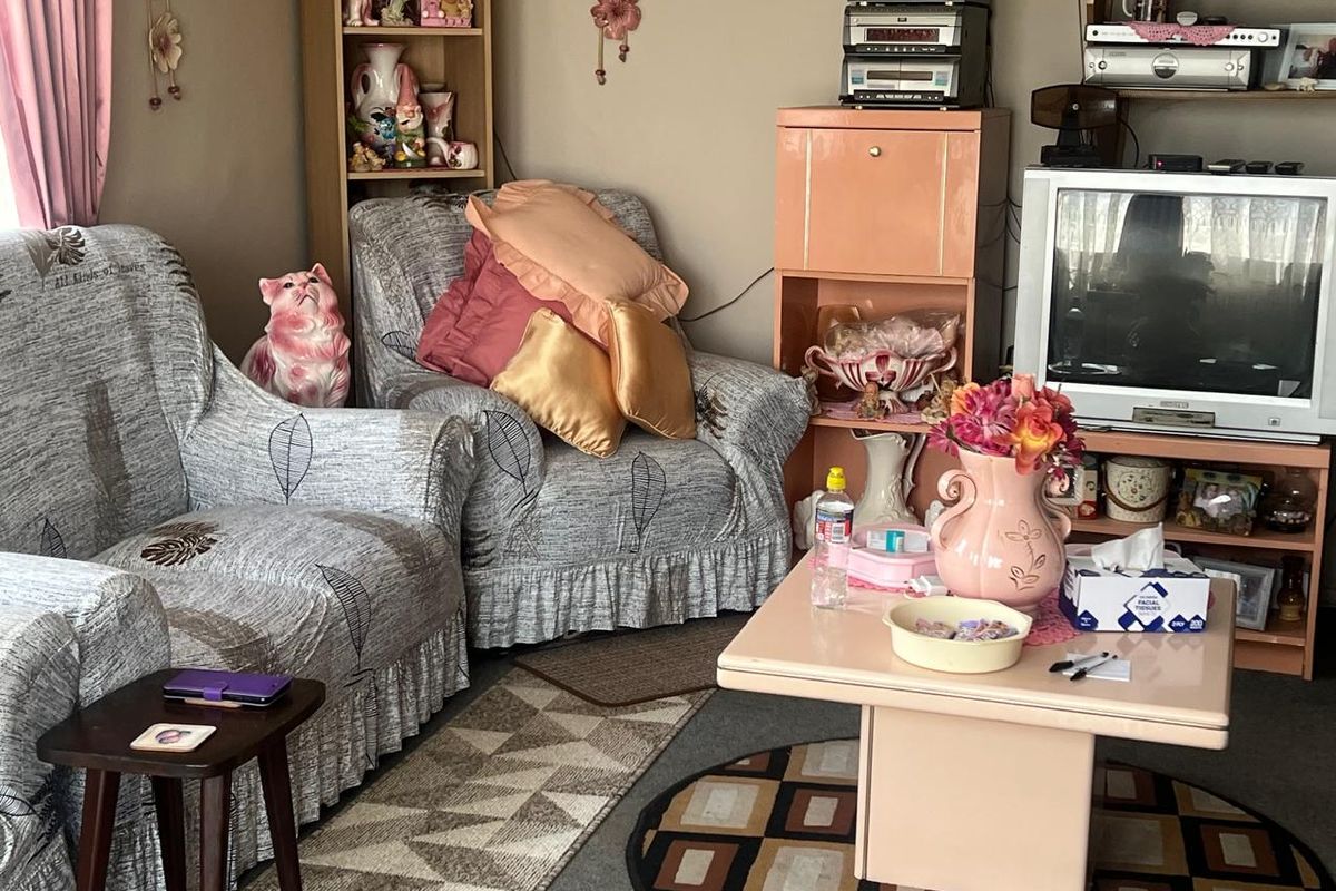 A living room space featuring standard residential finishes, currently occupied by personal belongings and furniture.