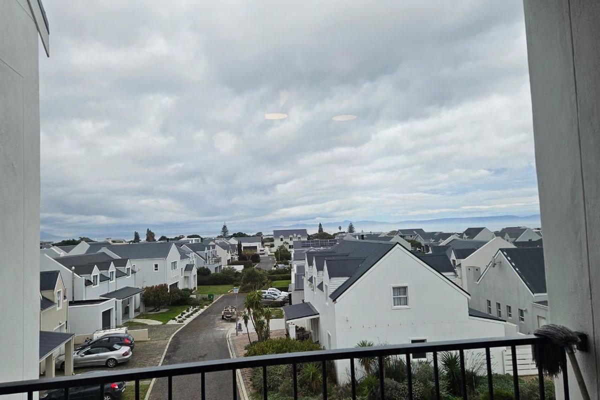 Elevated view overlooking the residential estate and surrounding neighbourhood, captured from a balcony with a metal balustrade.