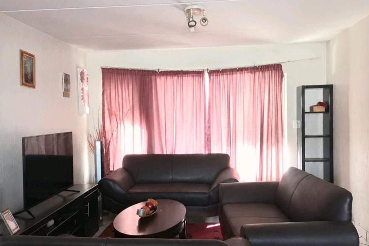 A living room featuring tiled flooring and a central ceiling light fixture, providing a functional space for relaxation.