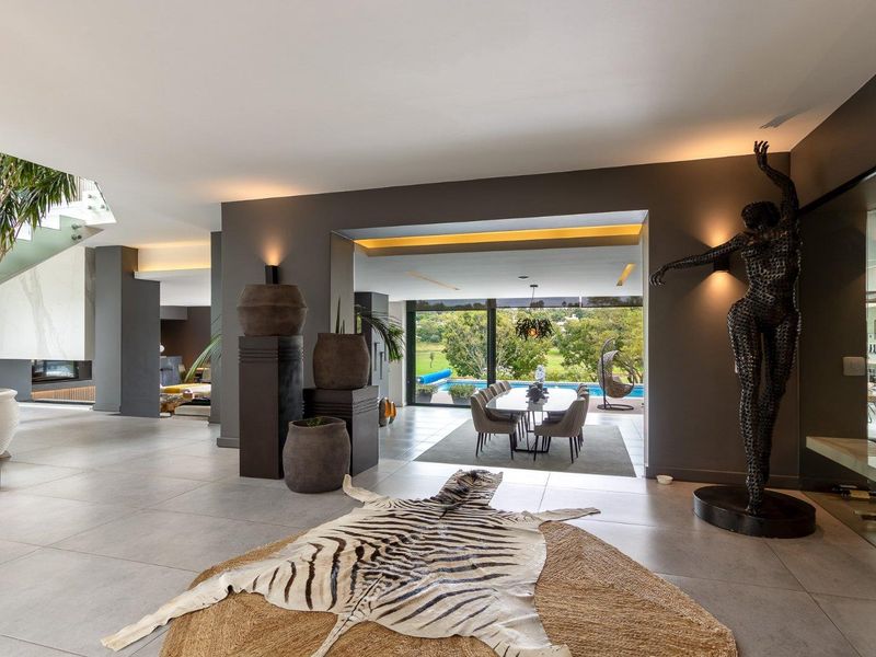 Spacious open-plan living area featuring large format floor tiles, modern recessed lighting, and seamless flow to the outdoor patio and pool area.