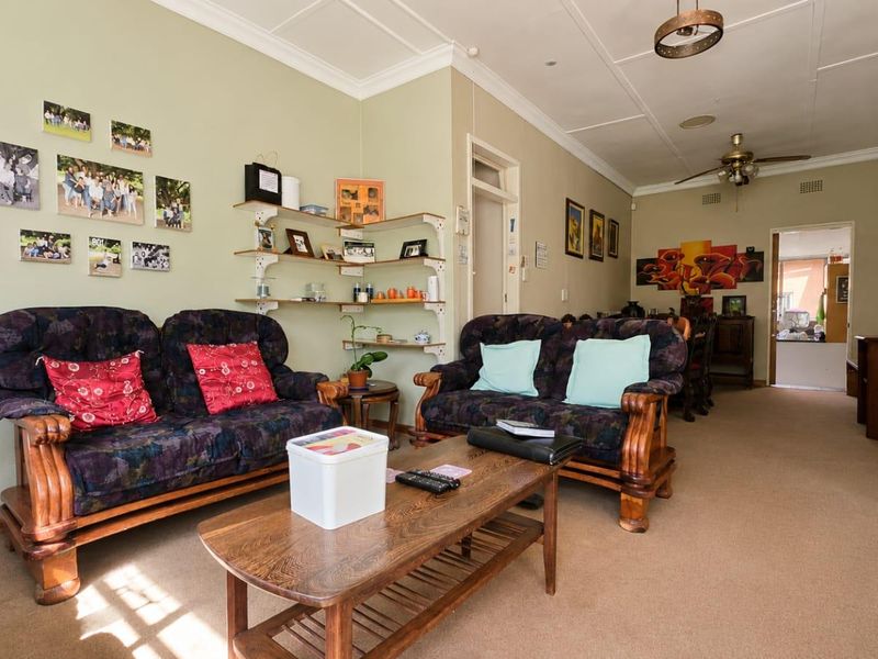 Spacious open-plan living area featuring neutral walls, crown molding, and carpeted flooring, offering a versatile layout for comfortable family living.