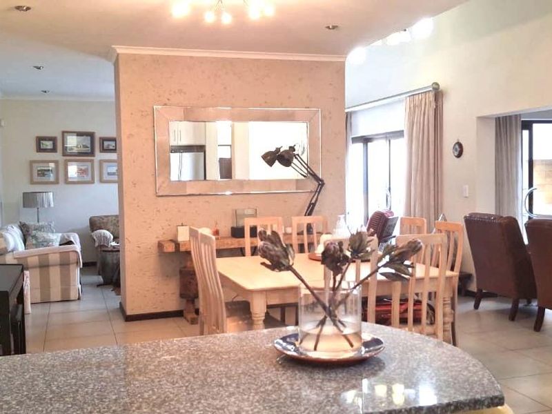 Spacious open-plan living and dining area featuring tiled flooring, granite kitchen counter, and sliding glass doors leading to the outdoor space.