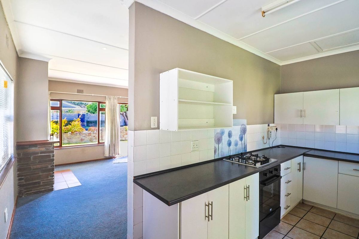 Functional kitchen featuring built-in cabinetry, gas hob, and oven, with an open-plan layout connecting to the adjacent living area.