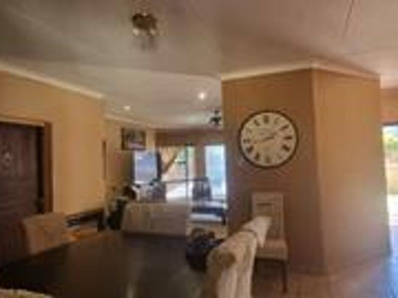 Spacious open-plan living and dining area featuring tiled flooring, recessed lighting, and direct access to the outdoor patio through sliding glass doors.