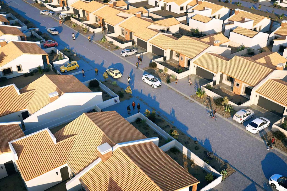 An aerial view of a modern townhouse development featuring uniform architectural styles, tiled roofs, and paved street access.