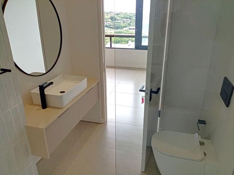 Modern bathroom featuring a wall-mounted vanity with a vessel sink, black fixtures, and a walk-in shower with clean tiled finishes.