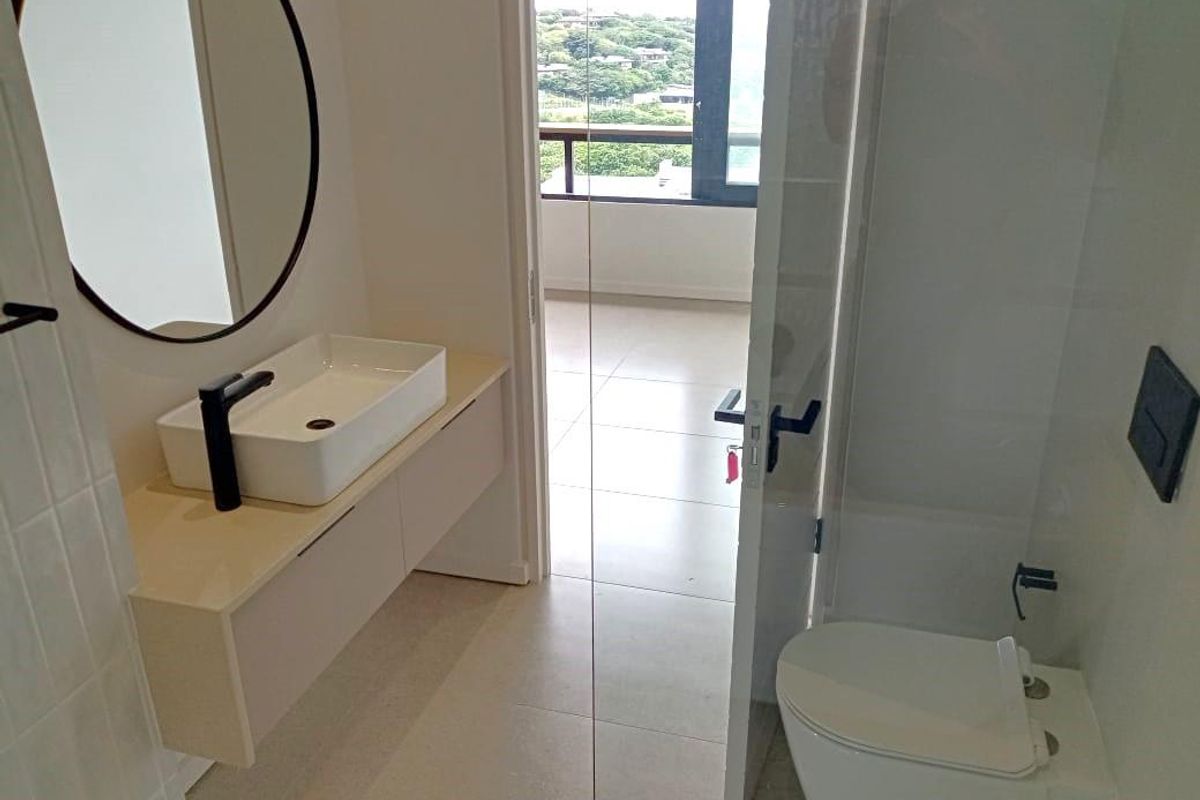 Modern bathroom featuring a wall-mounted vanity with a vessel sink, black fixtures, and a walk-in shower with clean tiled finishes.