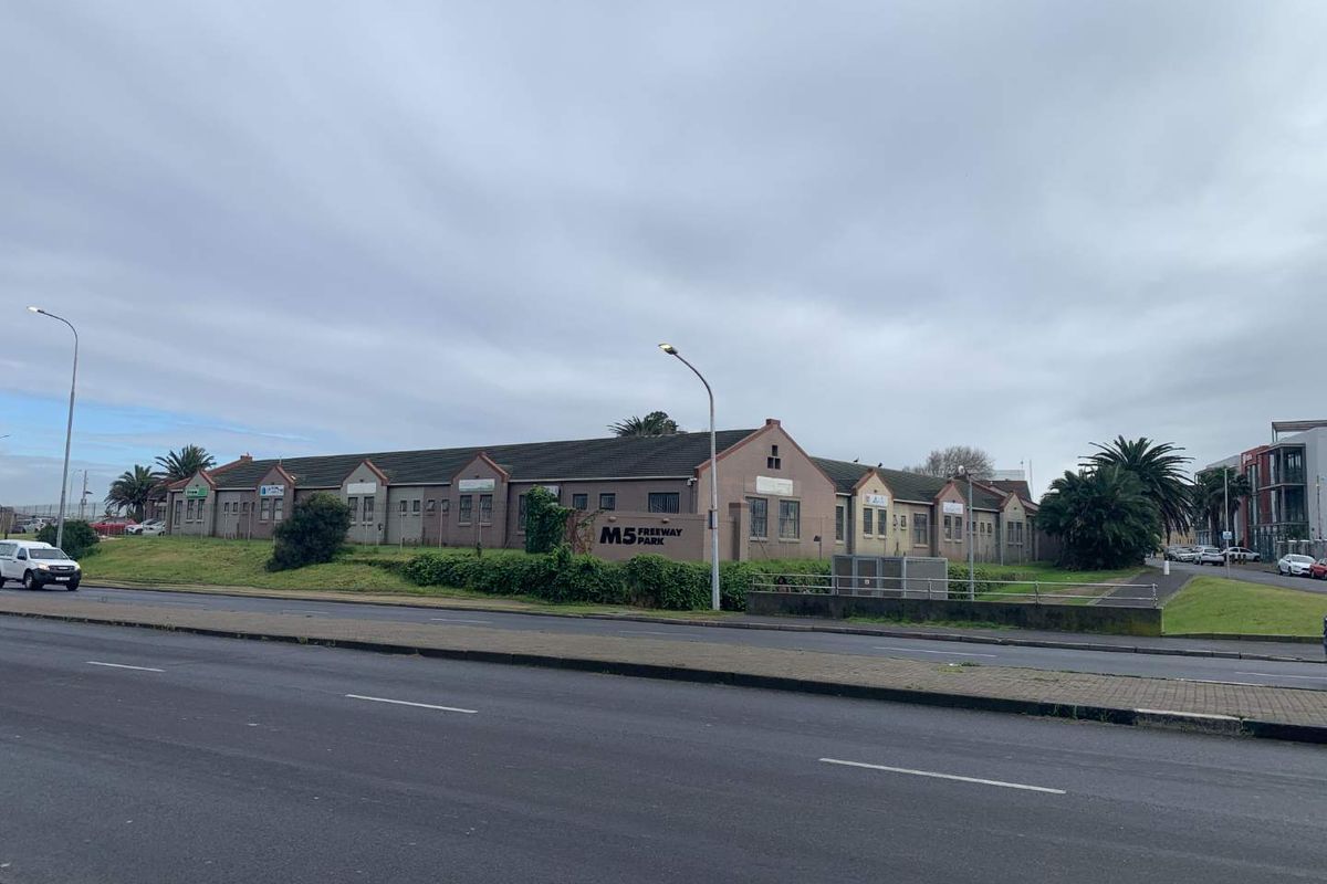 Exterior view of the M5 Freeway Park commercial complex, featuring a long single-story building with a tiled roof and prominent street-facing signage.