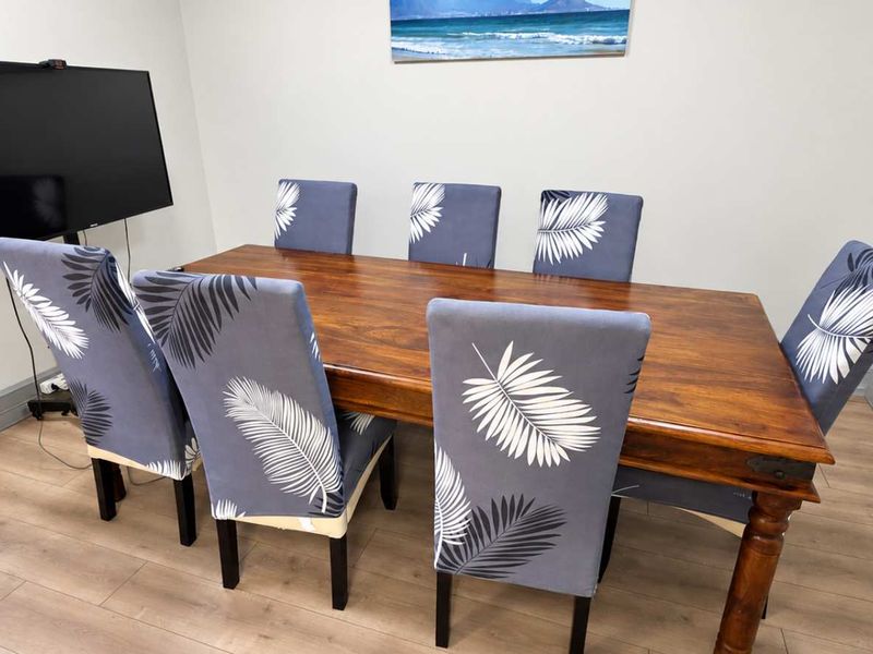 A functional office space featuring durable laminate flooring and neutral wall finishes, suitable for a professional meeting or workspace environment.