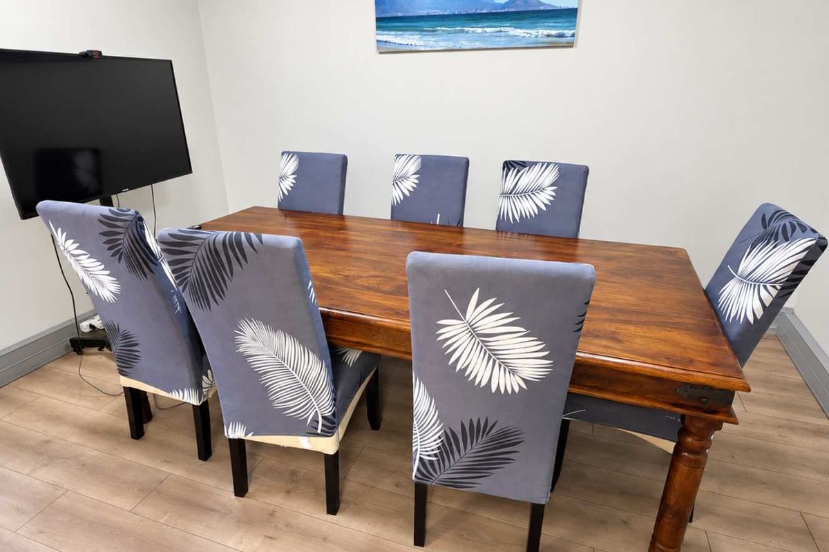 A functional office space featuring durable laminate flooring and neutral wall finishes, suitable for a professional meeting or workspace environment.