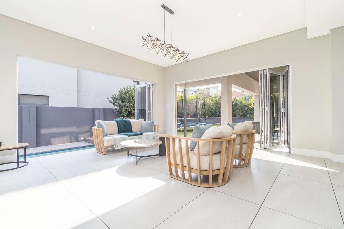 Bright and modern living area featuring large bi-fold doors that open onto the pool area, creating a seamless indoor-outdoor flow.
