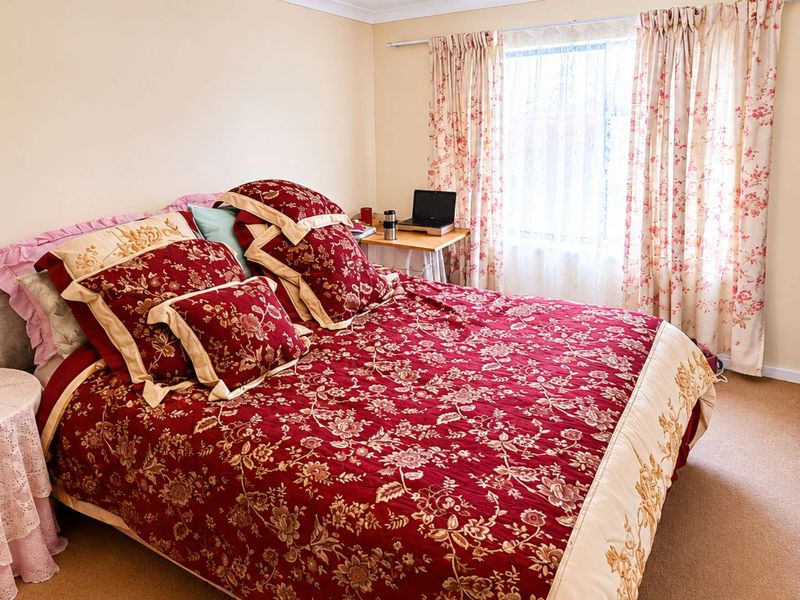 A functional bedroom featuring neutral wall tones, carpet flooring, and a built-in wardrobe, offering a comfortable and practical living space.