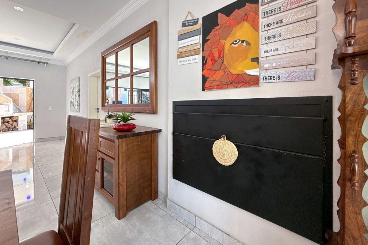 Interior view of a living area featuring tiled flooring, a built-in black fireplace or wall feature, and crown molding.
