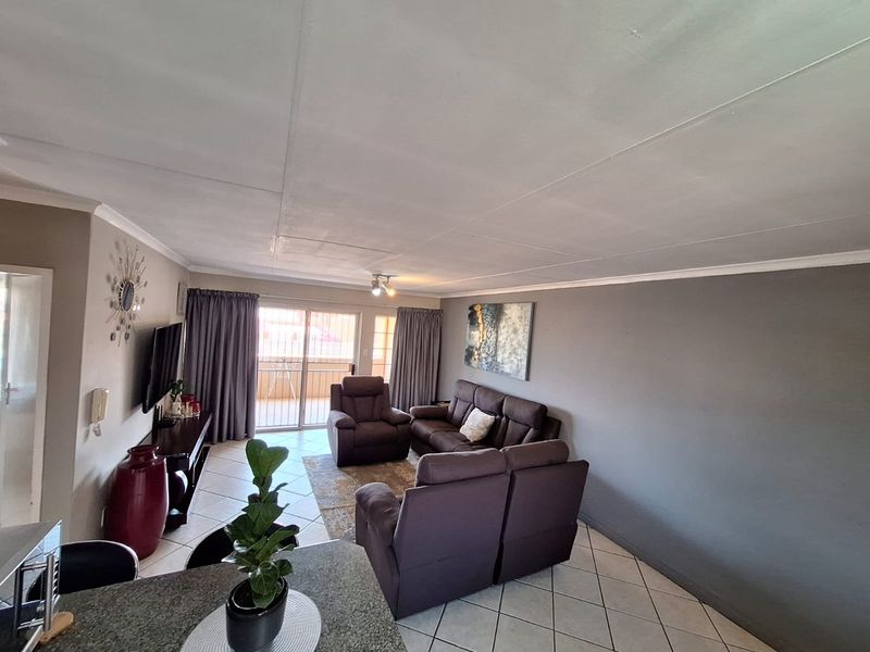 Open plan living area featuring tiled flooring and a sliding glass door leading to an outdoor balcony space.