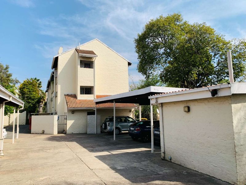 Front exterior view of the residential property featuring a concrete driveway and covered carport parking area.
