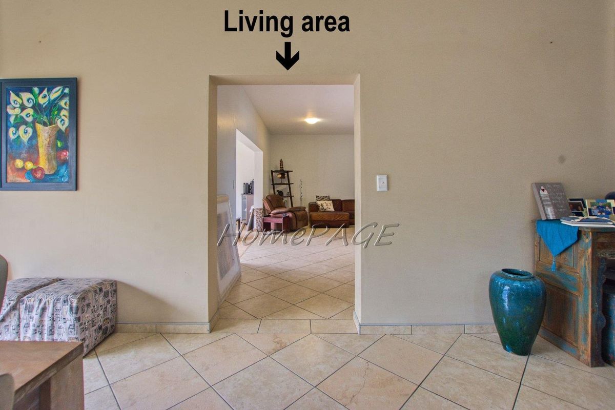 A view through a doorway into a living area featuring tiled flooring and neutral wall finishes.