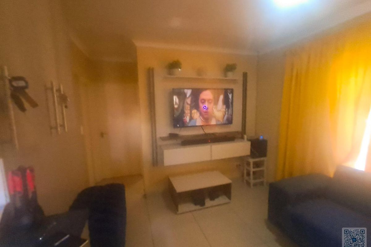 A living room featuring a built-in media unit and tiled flooring, providing a functional space for entertainment.