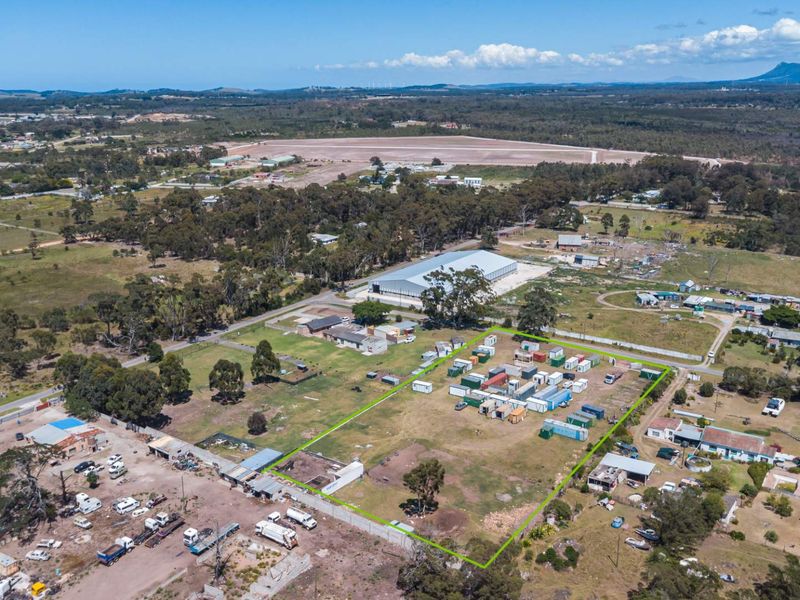 Aerial view of a vacant residential land parcel with perimeter fencing, situated in a semi-rural area with surrounding infrastructure.
