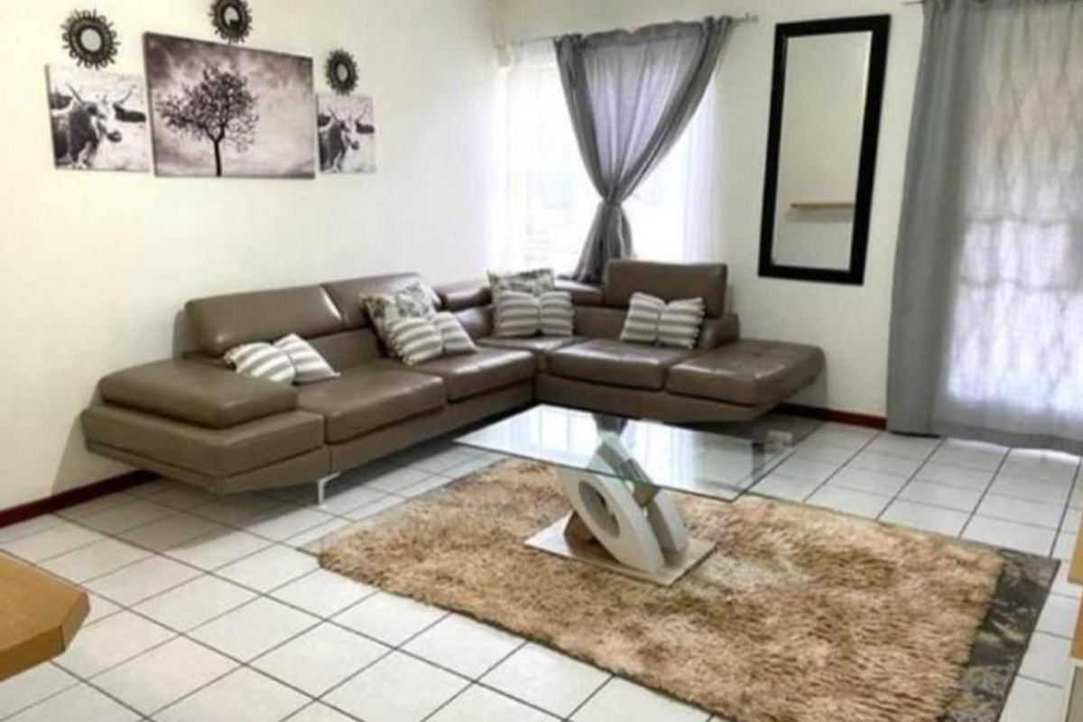 A living room area featuring tiled flooring and a sliding glass door providing access to the exterior.