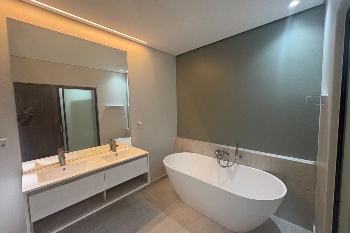 Modern bathroom featuring a sleek double vanity, a contemporary freestanding bathtub, and elegant recessed lighting in a clean, minimalist design.