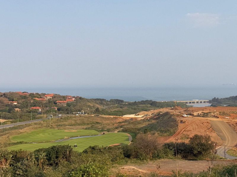 An elevated view overlooking a golf course, coastal landscape, and surrounding residential development.